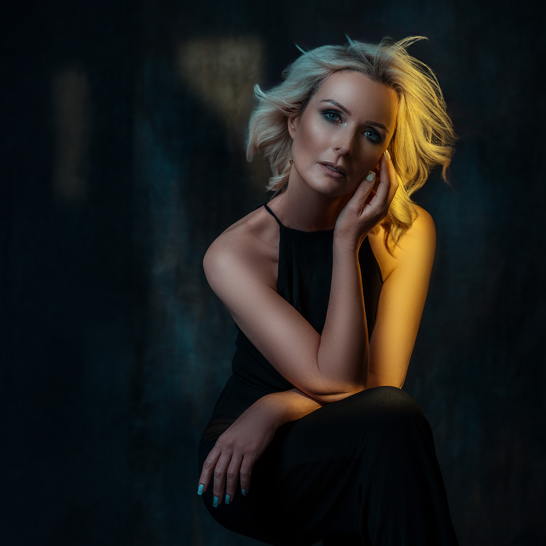 Fotograf portretowy Warszawa – blondynka o krótkich falowanych włosach w czarnej sukience, portret w ciepłym złotym świetle